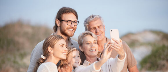 Familien-Selfie am Strand: Großeltern, Eltern und Kinder genießen gemeinsam den Urlaub am Meer